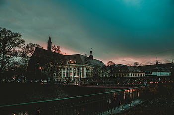 historic buildings, river view, serene cityscape, European architecture, twilight scene, urban landscape, architectural landmarks, waterfront scenery, evening ambiance, city at dusk, riverfront buildings