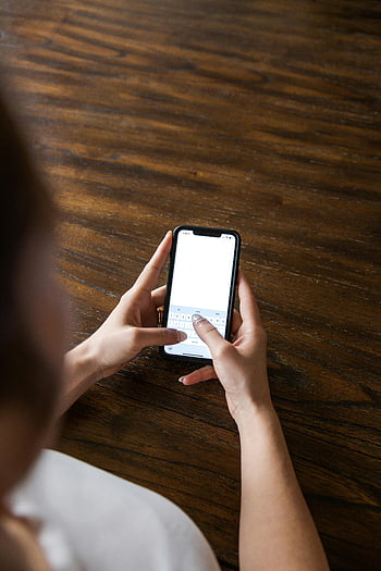 πρόσωπο που κατέχει το iPhone, γραπτά μηνύματα κοντινού χεριού, smartphone, ξύλινο φόντο επιφάνειας, Γραπτά μηνύματα στο τηλέφωνο, iphone, Χέρια στο τηλέφωνο, ξύλινο τραπέζι, κινητή συσκευή, γραπτά μηνύματα, άτομο που χρησιμοποιεί τηλέφωνο