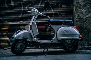 gray motor scooter, vintage scooter, graffiti-covered wall, Barcelona street, white scooter, parked scooter, urban scene, retro scooter, cityscape, street photography, scooter design