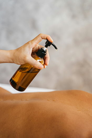 masážní terapeut, Aplikace oleje, holé záda, Relaxační masáž, Uklidňující lázně, terapeutka ruka, masážní olej, Nastavení lázní, péče o kůži, Wellness ošetření, aromaterapie olej
