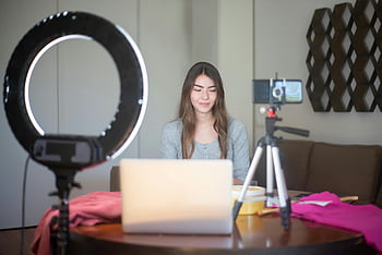 Frau Vlogging, junge Frau, Smartphone, Stativ, Ringlicht, Indoor -Setup, Vlogging -Geräte, Laptop, Inhaltsersteller, Home Vlogging, Inhalt in sozialen Medien