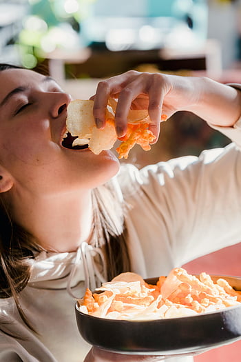 若い女性、 チップを食べる、 目を閉じて、 家、 スナックのボウル、 サクサクしたスナック、 暖かい日光、 屋内で、 食べ物を楽しむ、 カジュアルな瞬間、 屋内設定