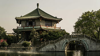 อาคารจีนโบราณ, สะพานโค้ง, มุมมองอันเงียบสงบ, เขียวขจี, แหล่งน้ำ, อาคารคอนกรีต, สีเขียวและเทา, โครงสร้างสถาปัตยกรรม, จุดสังเกตทางวัฒนธรรม, ทิวทัศน์ริมน้ำ, สถาปัตยกรรมประวัติศาสตร์