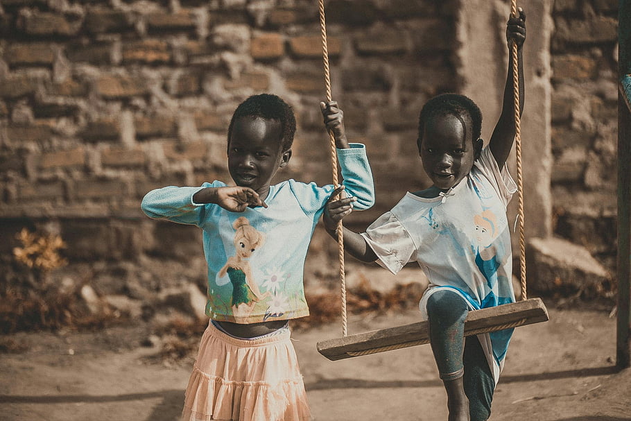 African children, swing, outdoors, blue shirt, playful moment, two children, outdoor play, children playing, swing set, African kids, blue clothing
