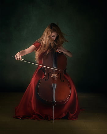 žena v červených šatech, hrát na violoncello, dramatické vnitřní prostředí, emoční hudba, červené šaty, vystoupení na violoncello, vnitřní hudební scéna, expresivní hudebník, klasická hudba, umělecká fotografie, dramatické osvětlení