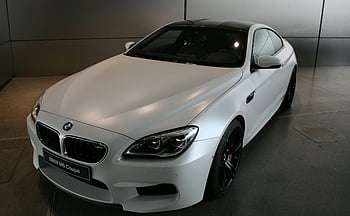 BMW M6 Coupé, white BMW, luxury car, showroom display, performance vehicle, sleek design, indoor parking, high-end automobile, modern coupe, BMW showroom, white coupe