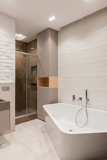 Badezimmer Interieur, Badewanne, Dusche, Helles Badezimmer, modernes Badezimmer, moderne Einrichtung, Schlanke Badewanne, Glasdusche, gefliestes Bad, Modernes Badezimmerdesign, Badezimmerdesign