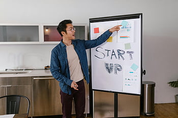 man i blå skjorta, pekar på papper, whiteboard, startplan, modernt kontor, presentation, affärsmöte, börja, kontorsinställning, man som presenterar
