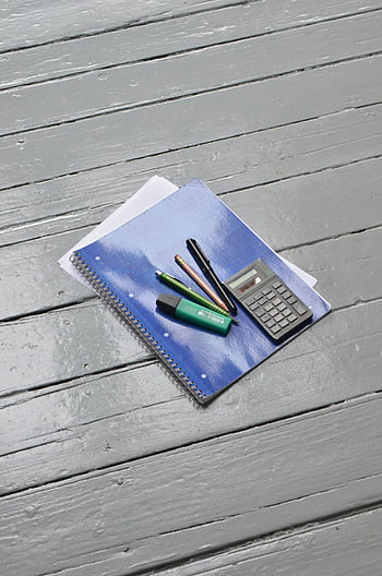 notebook, calculator, pens, pencils, study essentials, flat lay, wooden surface, study tools, educational supplies, desk setup, office supplies