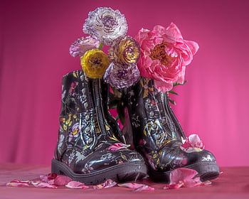 floral boots, colorful blooms, pink background, fashion display, decorative flowers, stylish shoes, artistic composition, vivid backdrop, floral design, boot art, shoe flowers