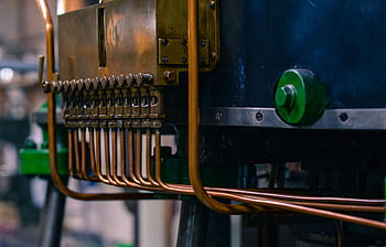 industrial machinery, copper tubing, steel components, factory setting, gray and blue machine, detailed view, industrial equipment, manufacturing process, mechanical parts, industrial components, factory machinery