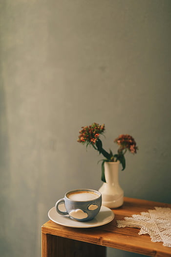 cappuccino, latte, foam, cloud-patterned cup, flower vase, rustic wooden table, flowers, table setting, coffee cup, lace doily, indoor scene