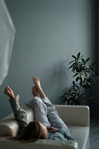 femeie relaxată, odihn, canapea, mână ridicată, atmosferă senină, Setare interioară, Poză casual, Viață confortabilă, Relaxare la domiciliu, moment pașnic, plante de interior