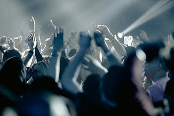 koncert hal, Spændt publikum, ydeevne, livlig natklub, energisk skare, hævede hænder, skarpt lys, musik begivenhed, Live musik, publikums engagement, Koncertatmosfære