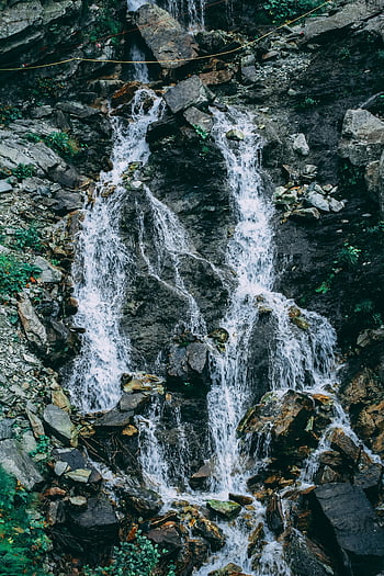 waterfalls, cascading waterfall, rocky terrain, lush greenery, natural scenery, mountain stream, flowing water, outdoor landscape, nature photography, serene environment, forest waterfall