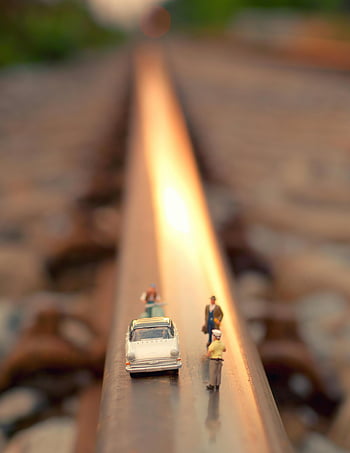 tilt shift lens, white car, toy people, miniature figures, toy car, railroad track, soft focus effect, miniature photography, model train, model car, miniature scene