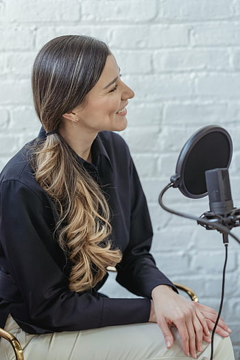 Szczęśliwa kobieta, Studio nadawcze, długie falowane włosy, Nagrywanie podcastu, Wesoła kobieta, Nagrywanie w pomieszczeniach, Nagrywanie podcastów, nagrywanie studyjne, kobieta nagrywa podcast, Profesjonalne nagranie, Studio wewnętrzne