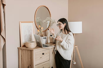 Mladá žena, videohovor, laptop, útulný obývací pokoj, moderní obývací pokoj, domácí kancelář, ležérní oblečení, Vnitřní nastavení, přirozené světlo, dřevěný nábytek, dekorační předměty