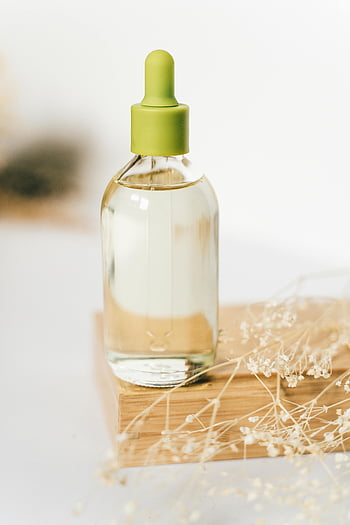láhev z čirého skla, Zelený kapátko, kapalný, dřevěná deska, sušené květiny, esenciální olej, aromaterapie, přírodní produkt, péče o kůži, kosmetický výrobek, minimalistické nastavení