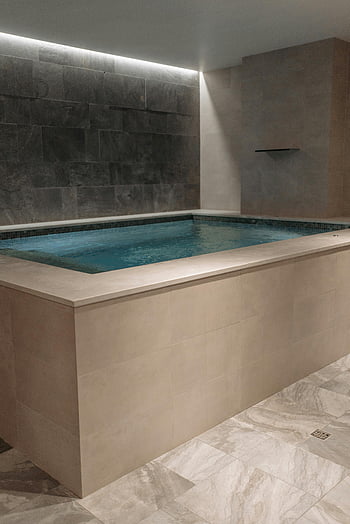 modern indoor spa, minimalist stone design, relaxation, luxury living, hot tub, indoor spa pool, brown and white, spa design, luxury spa, indoor hot tub, minimalist spa