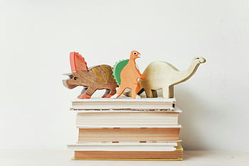 dřevěné dinosauři, Barevní dinosauři, Stoh knih, vázané knihy, světlé pozadí, hračky dinosaury, dřevěné hračky, hračky dinosaurů, Vzdělávací hračky, dětské hračky, dekorativní knihy