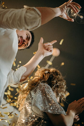 New Year's Eve, celebrating, confetti, sparkling wine, indoors, night, man, woman, joy, party, celebration