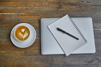 plano, taza de té de café con leche, platillo, cuaderno, bolígrafo, ordenador portátil, mesa de madera rústica, taza de café, arte latte, espacio de trabajo, vista superior