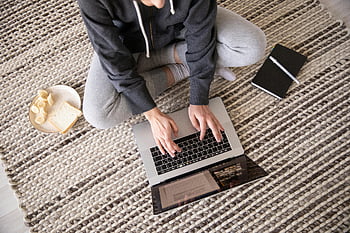 kvinde ved hjælp af bærbar computer, normalt tøj, arbejder fjernt, notesbog, snack, etage, tæppe, hjemmekontor, fjernbetjening, Komfortabel indstilling, produktivitet