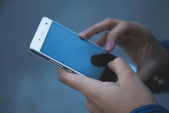 스마트 폰을 들고있는 사람, 흰색 스마트 폰, 현대 통신 기술, 캐주얼 설정, 전화를 들고 손, 옥외 설정, 스마트 폰 기술, 통신 장치, 모바일 기술, 캐주얼 사용, 스마트 폰
