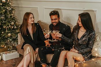 New Year's Eve, champagne, Christmas tree, friends celebrating, indoor celebration, holiday toast, festive gathering, holiday drinks, festive atmosphere, holiday party, New Year celebration