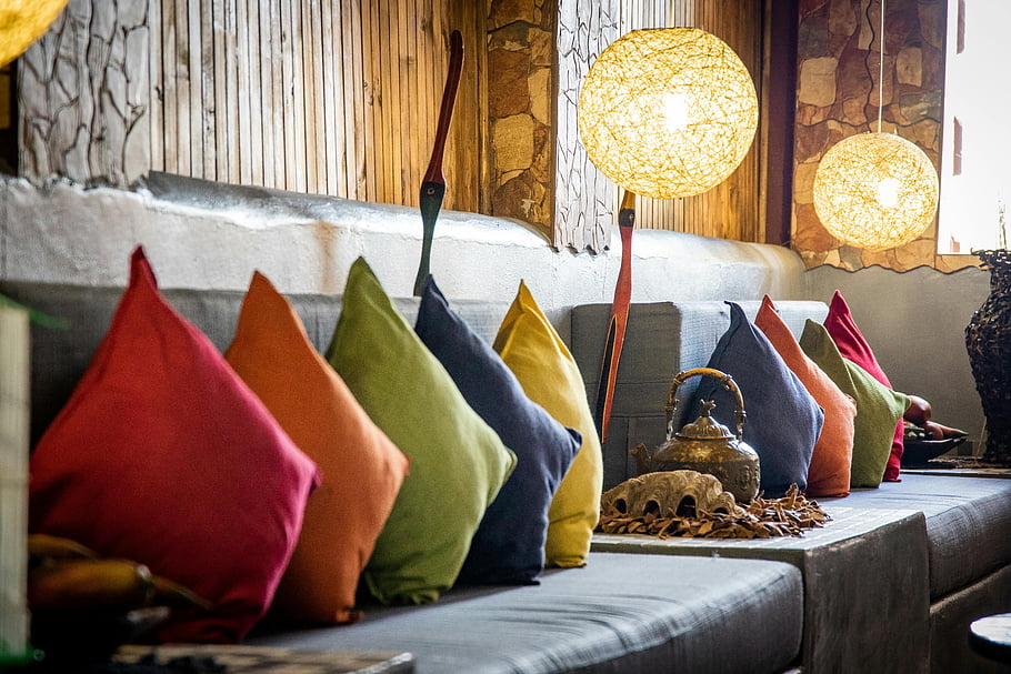 assorted colored throw pillows, vibrant cushions, warm lighting, cozy atmosphere, inviting living room, decorative pillows, interior design, home decor, living room decor, colorful pillows, ambient lighting