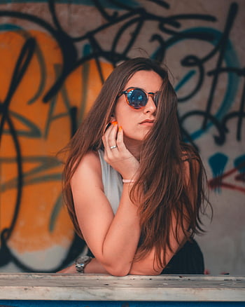 fashionable woman, sunglasses, vibrant graffiti, portrait, stylish pose, urban art, trendy outfit, modern look, artistic background, casual chic, street style