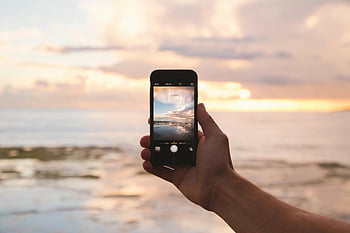 Space Grey iPhone 5S, tramonto, spiaggia, smartphone, mano che tiene il telefono, oceano, cielo, riflessione, fotografia, viaggio, natura