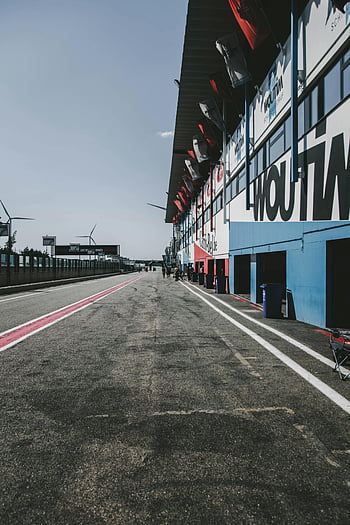 Gray Pavement, empty pit lane, race track, Heusden-Zolder, Belgium, clear sky, asphalt surface, motorsport venue, racing circuit, pit stop area, automotive sport