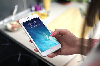 شخص يستخدم فضي iPhone،  لقطة مقرّبة،  عقد الهاتف الذكي،  إعداد المطبخ،  اقفل الشاشة،  اي فون الفضة،  الهاتف الذكي في المطبخ،  شخص يحمل الهاتف،  خلفية المطبخ،  شاشة قفل الهاتف الذكي،  فضي iPhone عن قرب