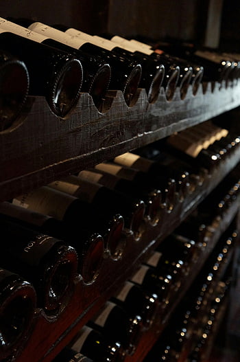wine cellar, dimly lit, rustic wooden shelves, rows of wine bottles, classic atmosphere, elegant atmosphere, wine storage, cellar shelves, wine collection, bottle display, dark ambiance