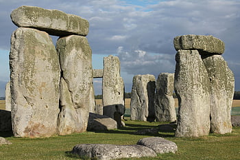 Stonehenge, dark clouds, megaliths, sunny day, ancient mystery, iconic stones, prehistoric monument, England, historical site, outdoor landscape, ancient architecture