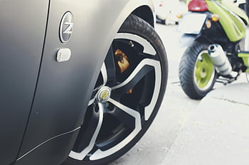 sports car wheel, modern design, gray vehicle, green motorcycle, close-up, street, detailed, style, car wheel, motorcycle, vehicle