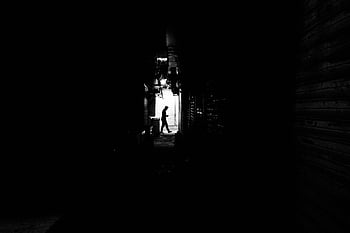 silhouette, man, black and white, dimly lit, alley, walking, shadow, urban, street photography, contrast, monochrome