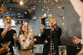 New Year celebration, colleagues celebrating, indoor celebration, champagne glasses, confetti falling, joy and togetherness, group celebration, festive atmosphere, office party, New Year's Eve, celebration moment