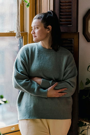 젊은 여성, 따뜻한 스웨터, 아늑한 스웨터, 밖을보고, 창을 바라 보는 창, 조용히 반영합니다, 실내, 창보기, 실내 장면, 캐주얼 복장, 가정 설정