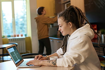 žena pomocí přenosného počítače, mělké zaměření, Mladá žena, dredy, příležitostná kuchyně, pracovat na notebooku, vnitřní prostředí, příležitostné nastavení, práce s notebookem, Kuchyňský pracovní prostor, Žena s dredy