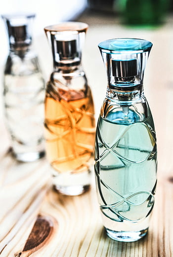 perfume bottles, clear glass, wooden surface, colorful liquids, elegant design, artistic shot, spray bottles, assorted bottles, brown wood, perfume fragrance, decorative bottles