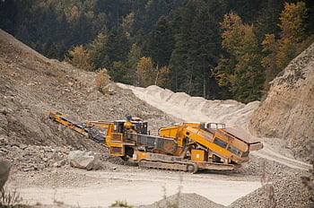 industrial crusher, quarry, mining machine, forest quarry, rugged terrain, large mining machine, operating machine, industrial equipment, quarry operation, mining industry, forested area