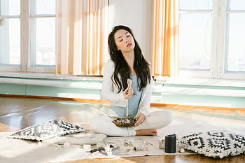 Asian woman meditating, sage smudge stick, serene meditation, indoor meditation, young woman meditating, crystals, indoor practice, peaceful meditation, meditation with sage, meditation indoors, crystals and sage