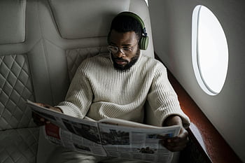 uomo che legge il giornale, aereo, cuffie, bicchieri, uomo d'affari, viaggio, jet privato, notizia, lettura, viaggio di lusso, passeggeri