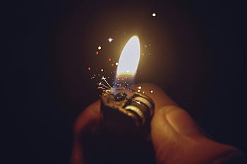 lighter, igniting, bright flame, spark effects, dark background, close-up, intense, hand holding, sparkles, fire, ignition