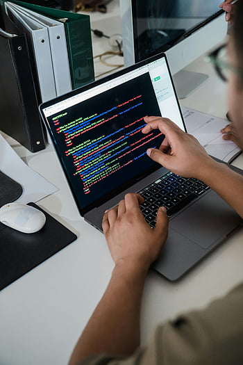 man pointing code, laptop screen, colorful code script, programmer, office setting, close-up, coding, software development, computer screen, work desk, hands typing