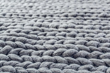 gray cable knit, close-up knit cloth, macro photograph, intricate details, grey knitted wool, wool fibers, cable knit texture, detailed knit pattern, soft texture, textile close-up, fabric texture