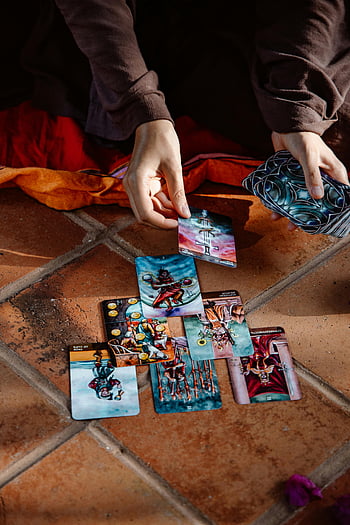 kartu tarot, membaca tarot, tangan, lantai keramik, Suasana mistis, tampilan close-up, membaca kartu, ramalan, latihan spiritual, tarot deck, penyebaran kartu tarot